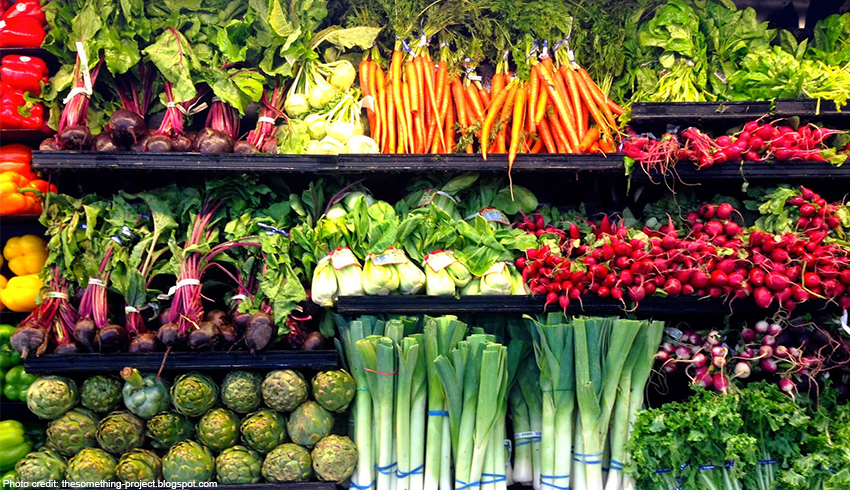 A display of grocery produce shelves stocked with fresh vegetables.